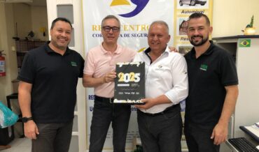 Na imagem aparecem quatro homens, sorridentes. Eles registram a renovação da parceria para 2025. Da esquerda para direita, está Gerente Regional Sucursal da HDI Seguros - Santa Cruz do Sul, Edmilson Cesar Alves, ele tem os cabelos pretos, pele clara e veste uma camiseta preta com a logo da HDI e uma calça preta, ao lado dele ao centro, estão os sócios-fundadores da Rede Centrosul, Glevander Ruviaro da Silva e Roberval Bresolin. Ruviaro, tem cabelos castanho claro e está de óculos com armação escura. Ele veste uma camiseta de cor rosa claro e calças pretas e segura com a mão direita, uma placa que está escrito 2025 com números grandes. Ao lado dele, segurando a placa com a mão esquerda, está Bresolin, ele tem cabelos grisalhos e veste camisa branca, de magas longas, com a logomarca da rede e calças pretas. Ao lado dele, no canto direito da imagem, está o gerente de Contas de Santa Maria da HDI Seguros, Arion Silveira Corrêa, ele tem cabelos pretos, barba e veste a camiseta preta com a logo da HDI e calças pretas. Eles estão em frente ao banner da Rede Centrosul Corretora de Seguros.
